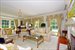 Formal living room with fireplace has floor to ceiling windows 