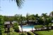Waterfront backyard with pool, dock & tiki hut